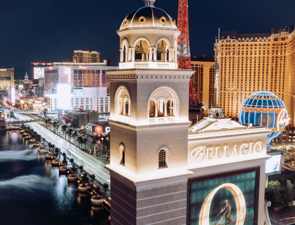 A long exposure photo that shows the view from the rooftop of The Cosmopolitan Hotel down the Las Vegas Strip during night time.