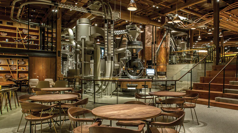 Starbucks Reserve Roastery in Seattle with copper coffee roasting machinery and visitors sipping drinks