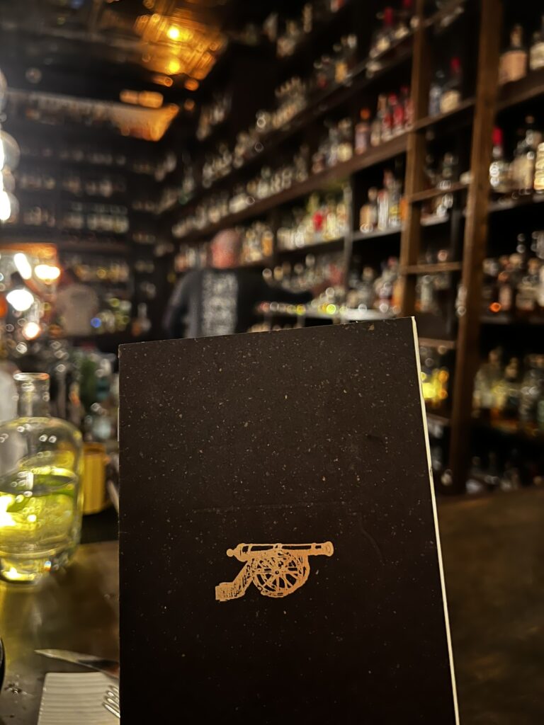 Closed menu at Canon and the whiskey bottles in the background
